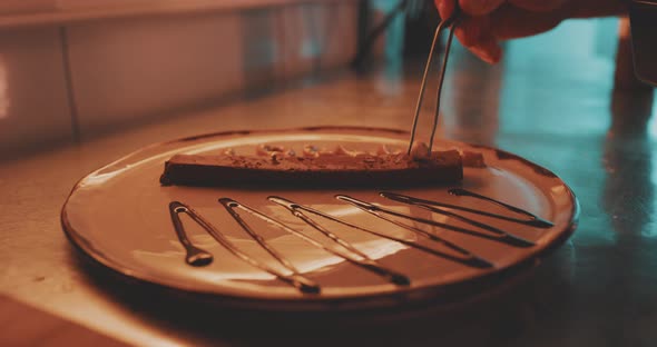 A professional chef is plating the dessert with fresh ingredients