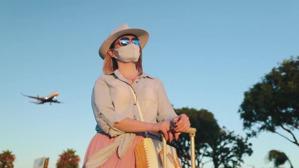 Safe Travels Under COVID-19. Summer Vacation 2020. Woman in Face Mask at Sunset