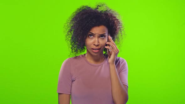 Young African American Woman Gossip Emotionally Talking on Phone in Green Studio