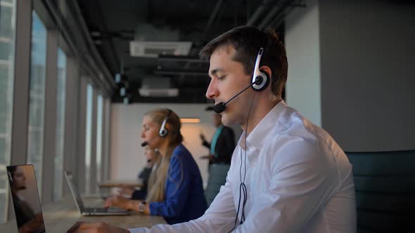 Handsome Worker in Headset Calling To Cuctomers in Business Office Call Center