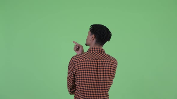 Rear View of Young African Man Directing and Pointing Finger