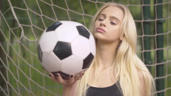 Close-up of Young Female Goalkeeper Posing with Ball on Outdoor Playground. Portrait of Confident