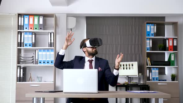 Revealing Dolly Slide Shot Businessman in Start Up Office Company Working with VR Goggles