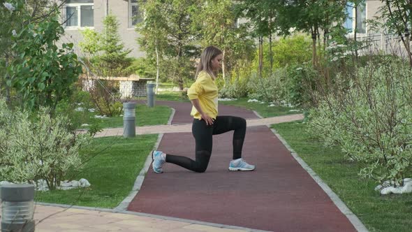 Young Sporty Woman Exercises on Street