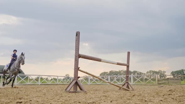 A Woman Jockey Jumps Over the Barriers on a Horse in a Jumping Competition