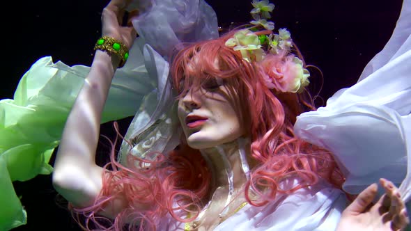 Young Woman with Pink Hair Is Floating Underwater