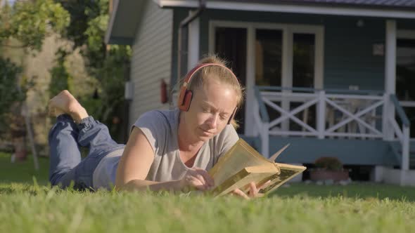 Woman in Headphones Lies on Lawn