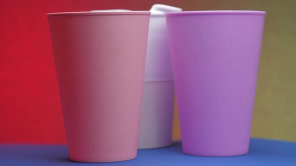 Purple White and Pink Beverage Cups Rotate on Blue Table