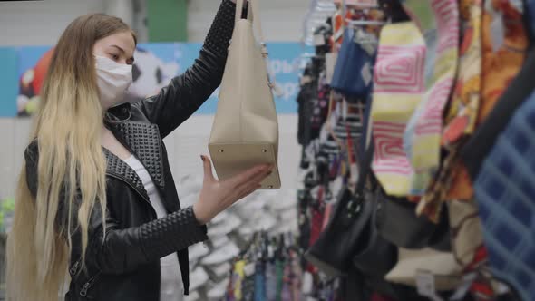 Young Woman in Medical Mask Buying Beige Bag in Shopping Center