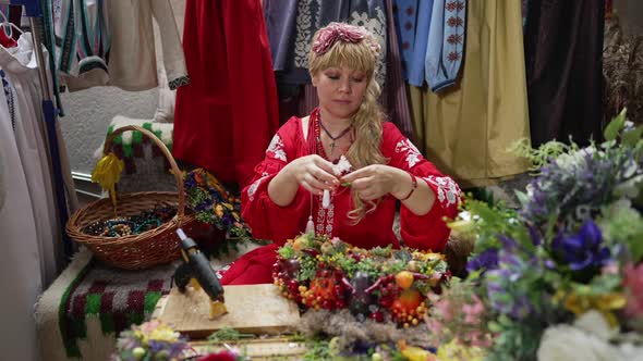 Front View Portrait of Confident Woman Gluing Decoration to Head Wreath Sitting at Table in Craft