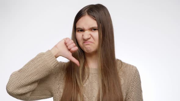 Portrait of Displeased Girl Putting a Dislike or Showing Thumbs Down Sign