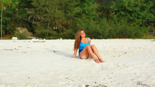 Beautiful smiling ladies on photoshoot having fun at the beach on summer white sand and blue 4K back