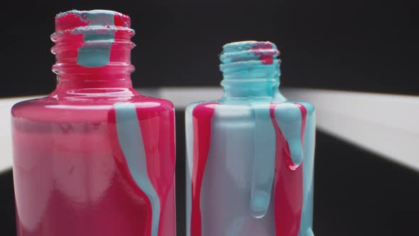 Pink and Blue Nail Polish Trickling down Bottles