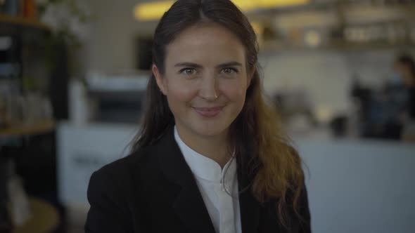 Portrait of Positive Young Caucasian Woman Looking at Camera and Smiling. Toothy Smile of Brunette