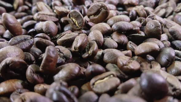 Closeup of Roasted Coffee Beans Bouncing on Coffee Texture in Super Slow Motion