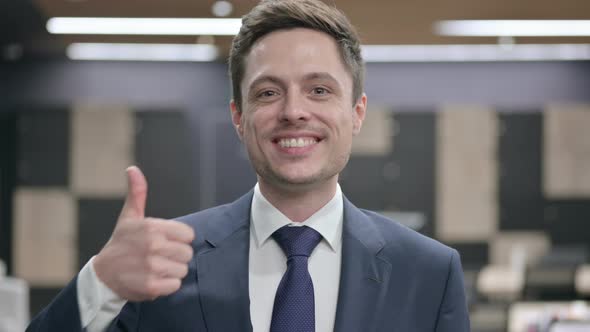 Portrait of Businessman with Laptop Showing Thumbs Up