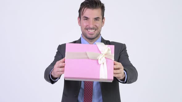 Young Happy Hispanic Businessman Giving Gift Box