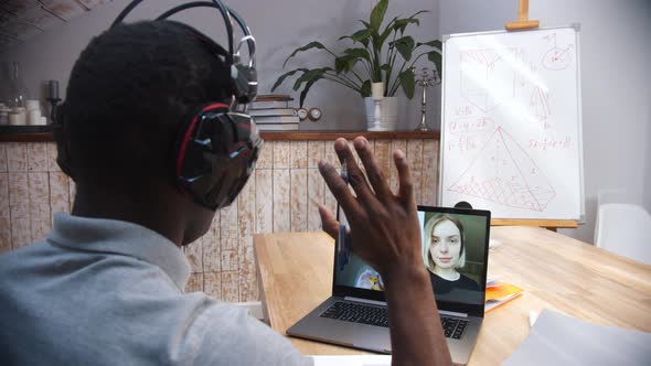 An Online Maths Lesson - a Black Man Teacher Greeting His Students on the Screen