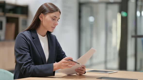 Woman Reading Documents in Office