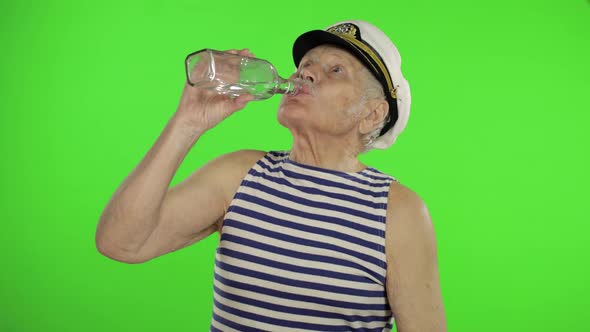 Elderly Sailor Man with Mustache Drinks Vodka. Old Sailorman on Chroma Key