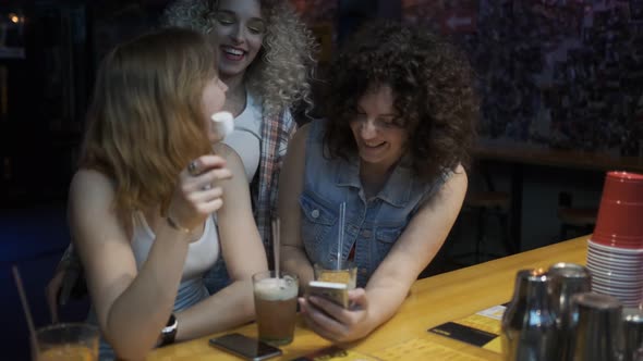 the Girls Are Sitting at the Bar in the Cafe and Chatting Merrily. Friendly Communication at a Party