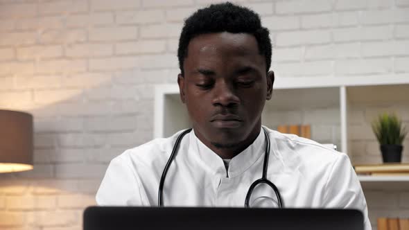 Close Up African American Man Doctor Working Uses Computer in Clinic Office