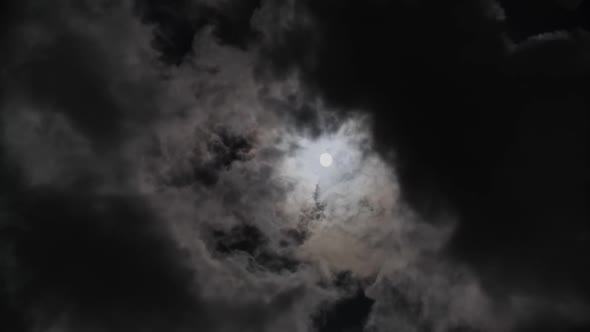 Full Moon Moving Between Clouds