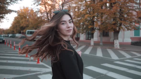 An Elegant Young Girl in a Stylish Black Outfit Crosses the Road at a Pedestrian Crossing and