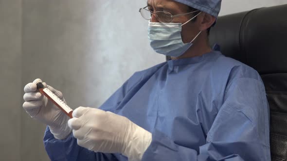 A doctor holds a test tube with a covid-19 test vaccine in his hand.