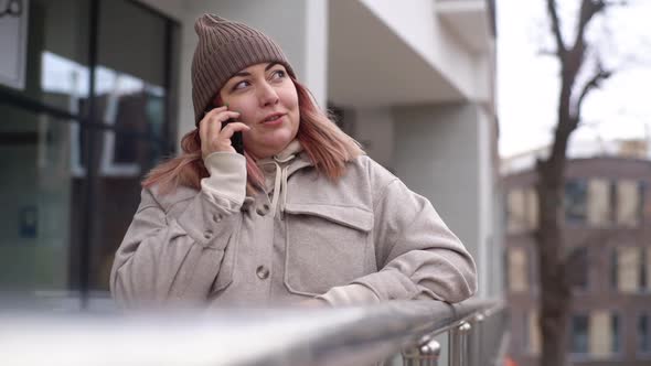 Portrait of Attractive Overweight Woman in Autumn Hat Talking on Mobile Phone Standing in City