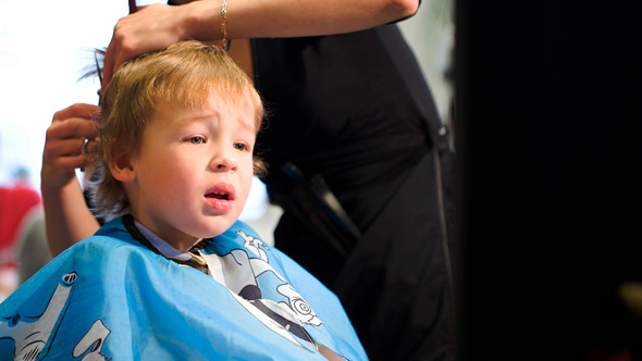 Boy Taking Off The Cape While During Haircut