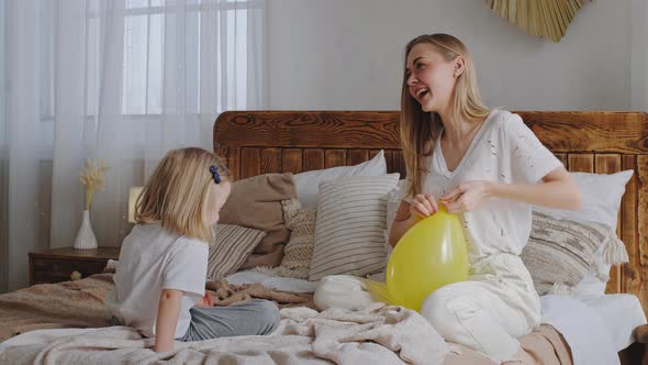 Caucasian Family Lonely Mother and Little Girl Child Sitting on Bed in Bedroom Talking Laughing