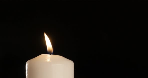 4K - blow out a candle on the black background