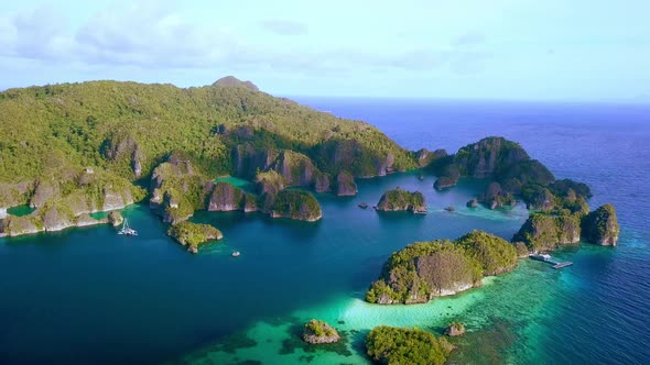 Wide view of Piaynemo island bay in Raja Ampat Indonesia with docking pier right and trimaran boat l