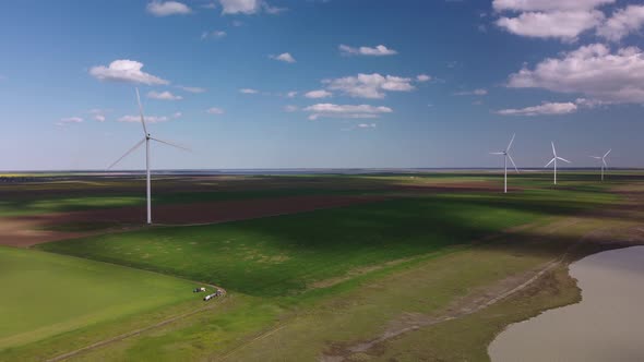 Aerial View of Wind Turbines and Agriculture Field Near the Sea at Sunset