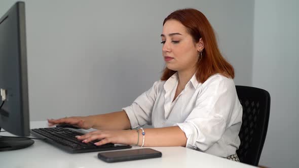 Woman Talking on Phone While Working on Computer in Office 4K