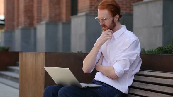 Pensive Designer Thinking While Working on Laptop