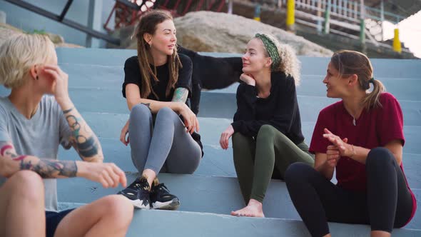 Group of Four Young Women, Best Friends Sitting Outdoor and Talking.