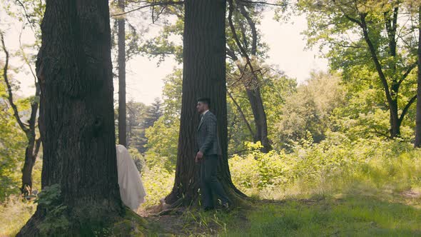 Young Couple Who Met in the Woods Near the Trees on a Background of Sunlight. The Newlyweds Gently