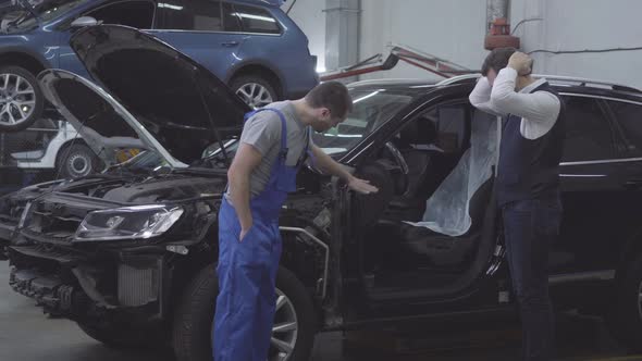 Adult Caucasian Man Standing Next To His Broken Car and Holding Head with Hands