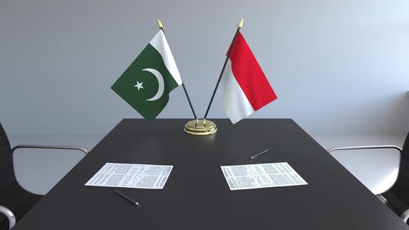 Flags of Pakistan and Indonesia and Papers on the Table