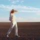 Young Confident Woman is walking on Sunny Day on Field in Straw Hat. - VideoHive Item for Sale