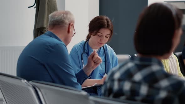 Medical Assistant Doing Consultation with Senior Patient in Waiting Area