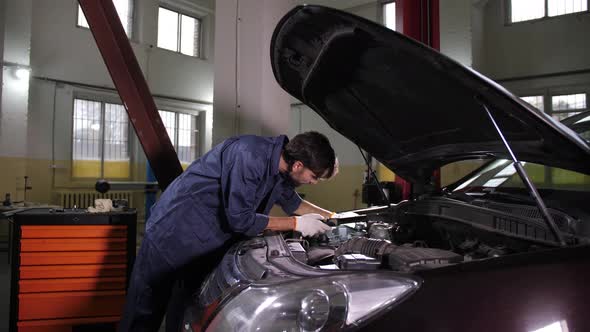 Handsome Repairman Looking Under Car Hood