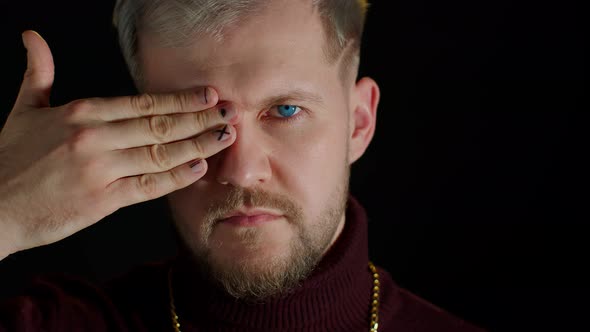 Confident Stylish Bearded Man in Sensually Looking at Camera with One Eye Posing Facial Expression