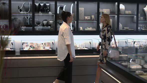 Wide Shot Slim Elegant Buyer and Confident Seller Walking in Jewellery Store Talking in Slow Motion