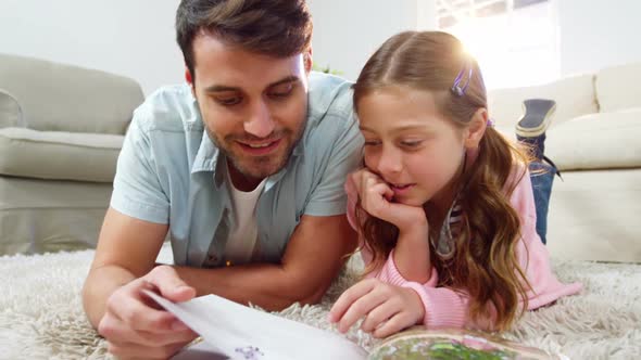 Father and daughter reading book in the living room