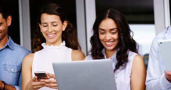 Happy executives using digital tablet, laptop and mobile phone