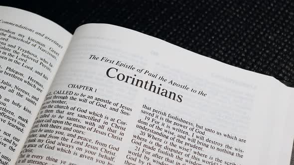 Close Up Shot of  Bible Page Turning to the book of First Corinthians