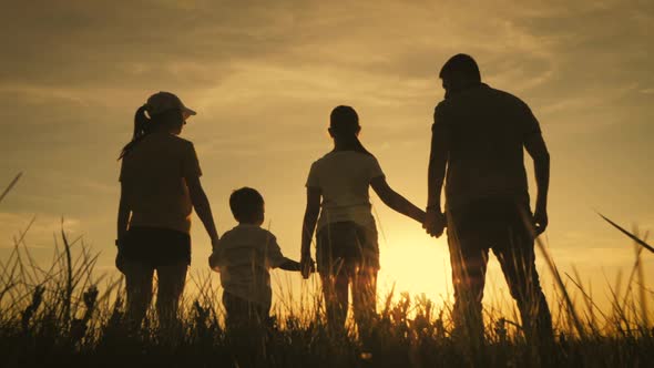 Happy Family Parents and Children Silhouettes Playing on Park